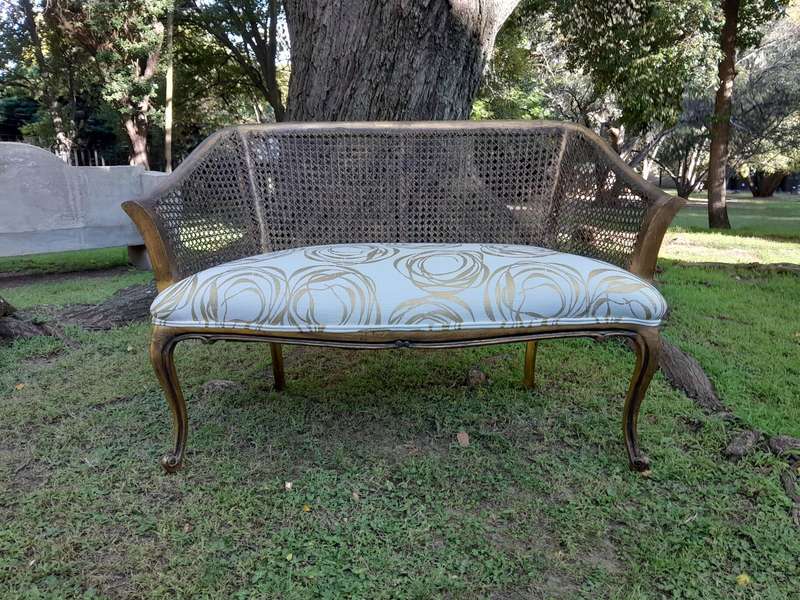 A Pair of French Style Carved and Gilded Wooden and Rattan Settees Upholstered in a Custom-Made L...