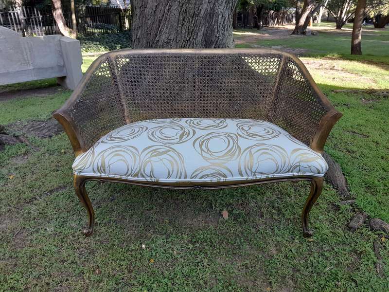 A Pair of French Style Carved and Gilded Wooden and Rattan Settees Upholstered in a Custom-Made L...