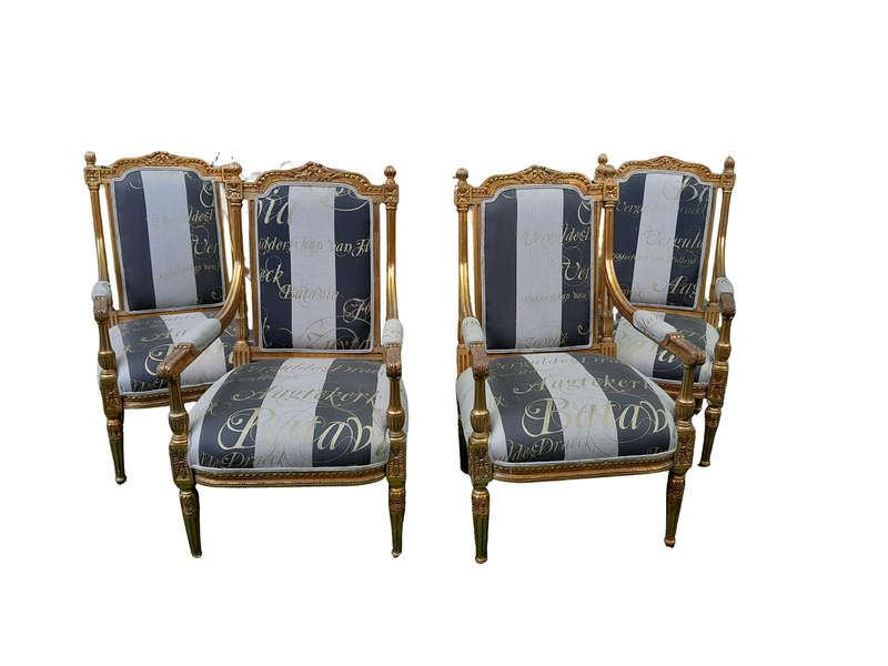 A French Style Set Of Four Ornately Carved And Gilded Armchairs In A Custom-Made Stripe And Scrip...