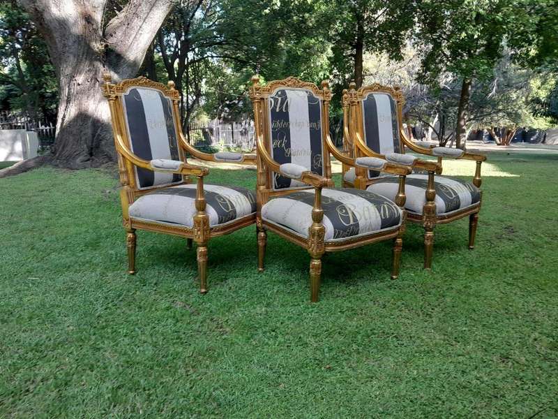 A French Style Set Of Four Ornately Carved And Gilded Armchairs In A Custom-Made Stripe And Scrip...