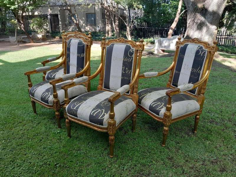 A French Style Set Of Four Ornately Carved And Gilded Armchairs In A Custom-Made Stripe And Scrip...