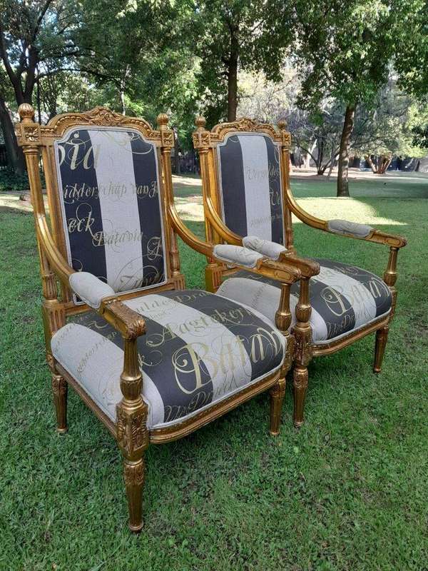 A French Style Set Of Four Ornately Carved And Gilded Armchairs In A Custom-Made Stripe And Scrip...