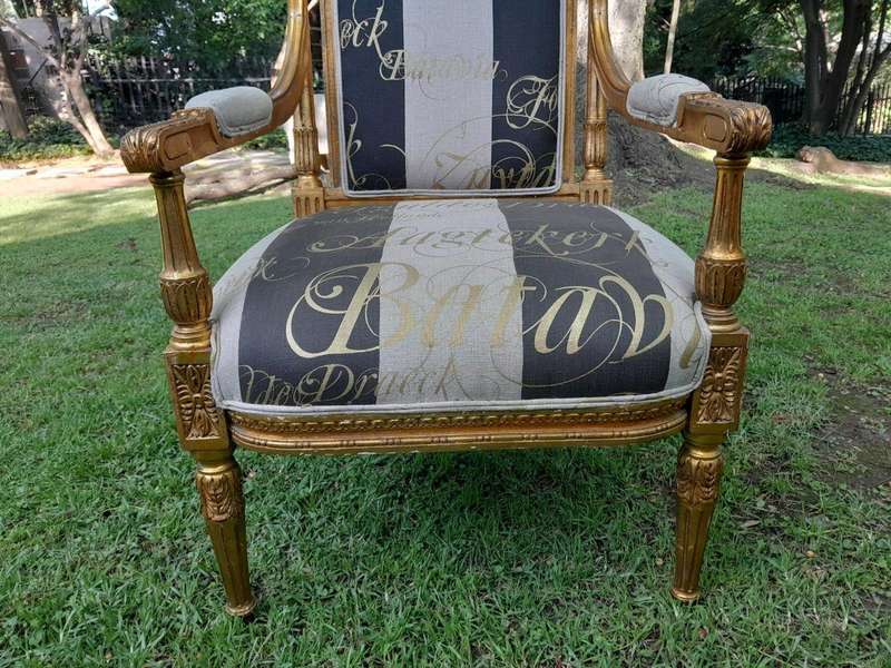 A French Style Set Of Four Ornately Carved And Gilded Armchairs In A Custom-Made Stripe And Scrip...
