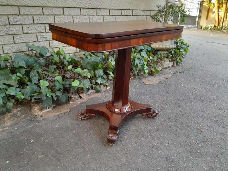 A Victorian rosewood swivel and tilt CARD TABLE, on spreading hexagonal column to the concave pla...