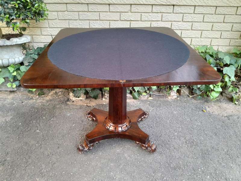 A Victorian rosewood swivel and tilt CARD TABLE, on spreading hexagonal column to the concave pla...