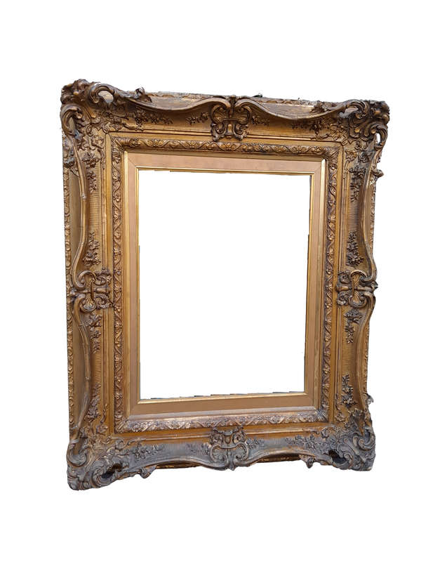 An Ornately Carved Gilt Framed Bevelled Mirror