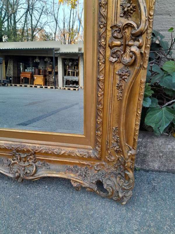 An Ornately Carved Gilt Framed Bevelled Mirror