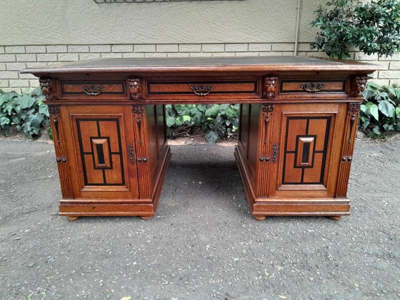 An Edwardian Circa 1910 Oak And Ebonised Desk With Gilt Tooled Green Leather Top Above Three Draw...
