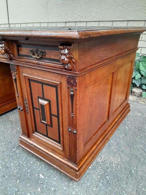 An Edwardian Circa 1910 Oak And Ebonised Desk With Gilt Tooled Green Leather Top Above Three Draw...