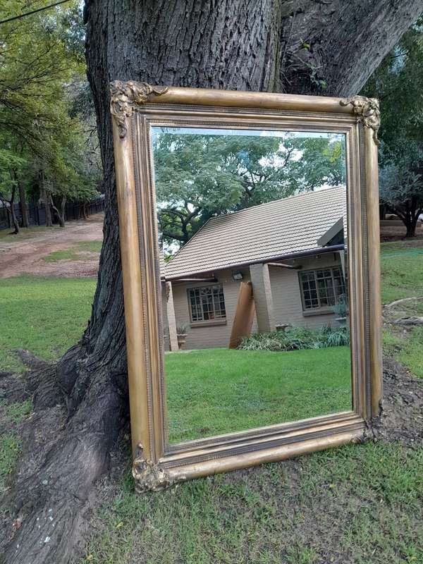 A 20th Century French Style Ornately Carved And Hand Gilded Bevelled Mirror