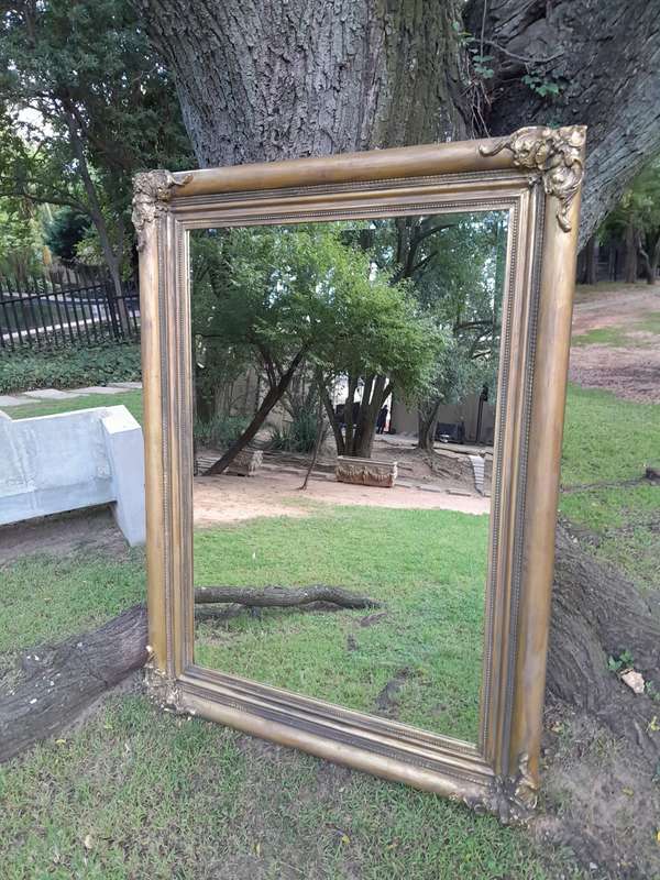 A 20th Century French Style Ornately Carved And Hand Gilded Bevelled Mirror