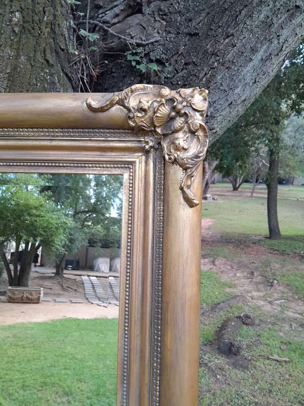 A 20th Century French Style Ornately Carved And Hand Gilded Bevelled Mirror