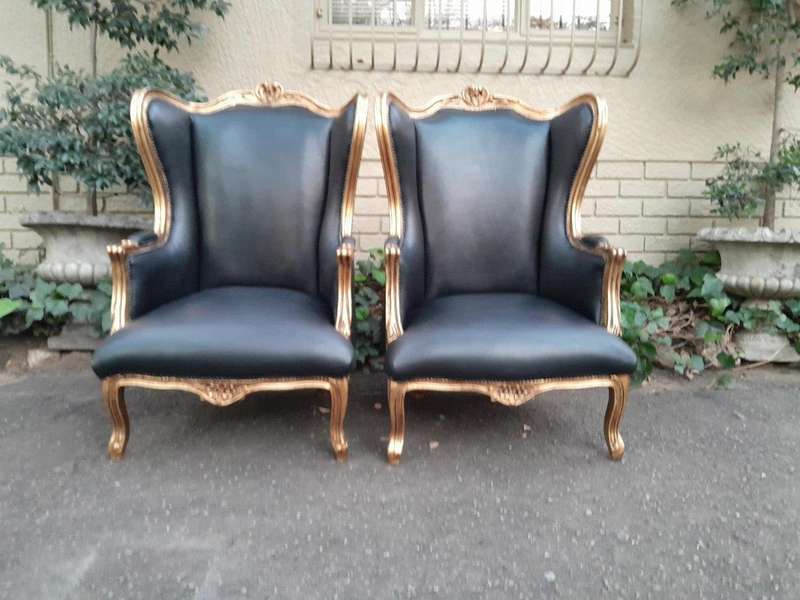 A Pair Of French Style Louis XVI Style Carved And Hand Gilded Wingback Chairs Upholstered In Leather