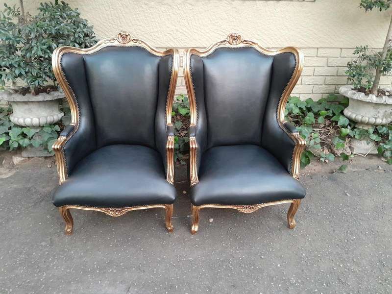 A Pair Of French Style Louis XVI Style Carved And Hand Gilded Wingback Chairs Upholstered In Leather