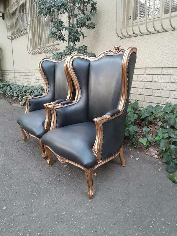 A Pair Of French Style Louis XVI Style Carved And Hand Gilded Wingback Chairs Upholstered In Leather