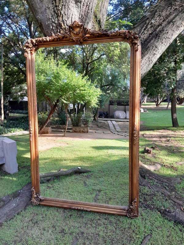 A Large French Style Ornately Carved and Gilded Bevelled Mirror