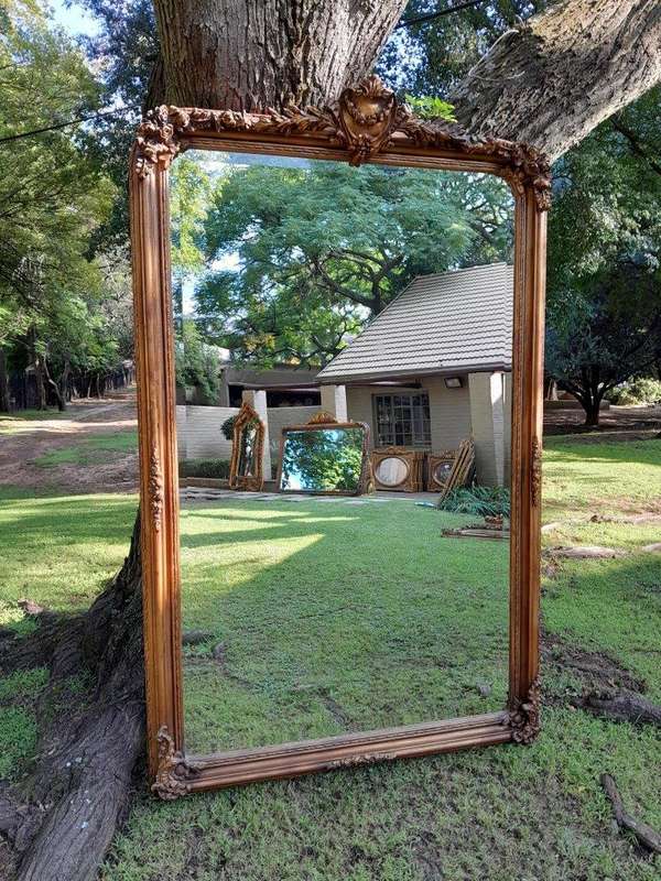 A Large French Style Ornately Carved and Gilded Bevelled Mirror
