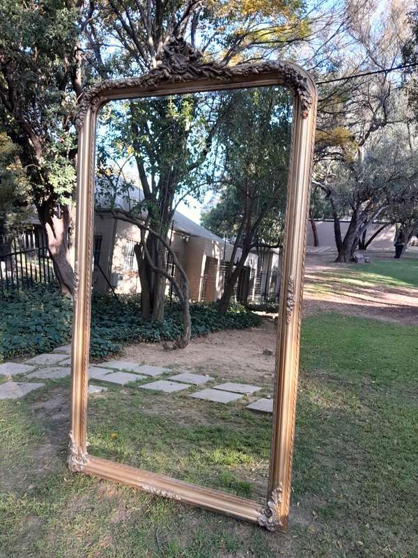 A Large French Style Ornately Carved and Gilded Bevelled Mirror