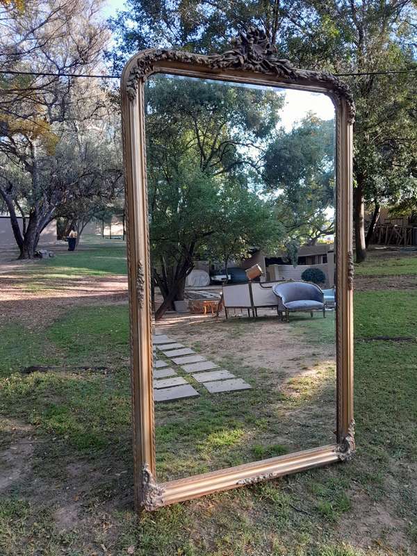 A Large French Style Ornately Carved and Gilded Bevelled Mirror