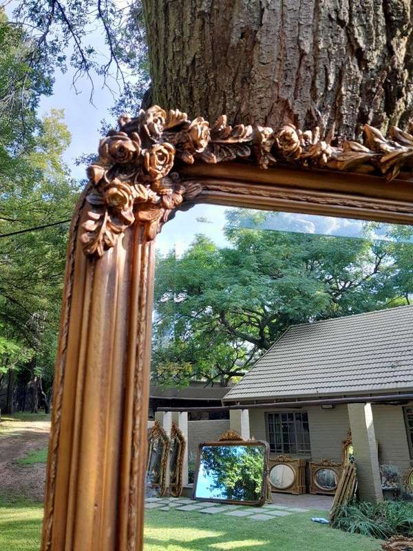 A Large French Style Ornately Carved and Gilded Bevelled Mirror