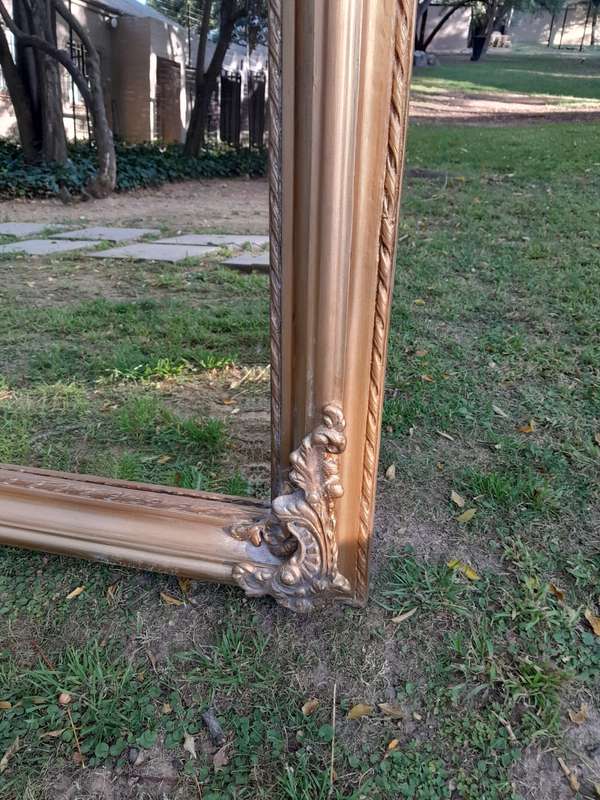 A Large French Style Ornately Carved and Gilded Bevelled Mirror