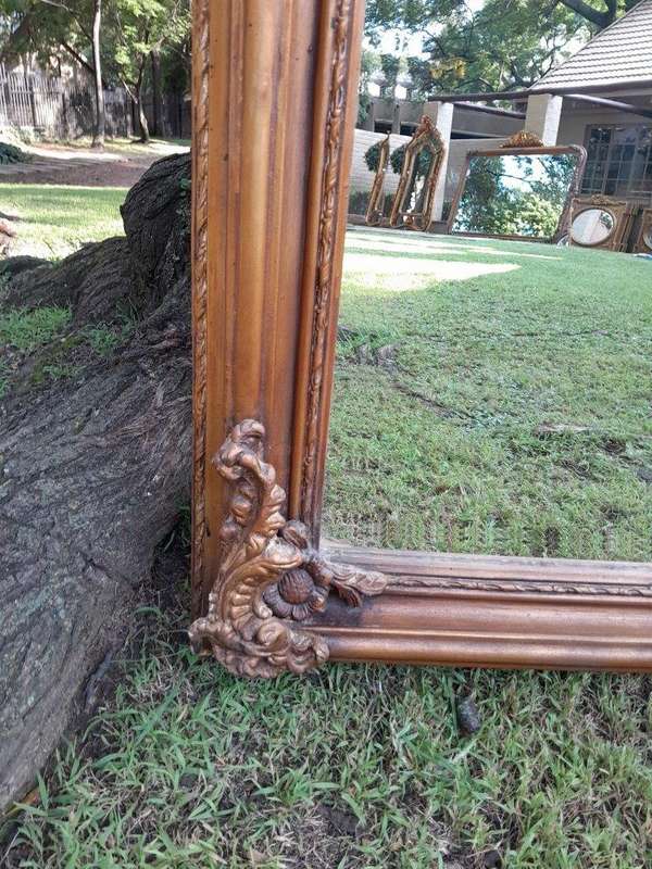 A Large French Style Ornately Carved and Gilded Bevelled Mirror