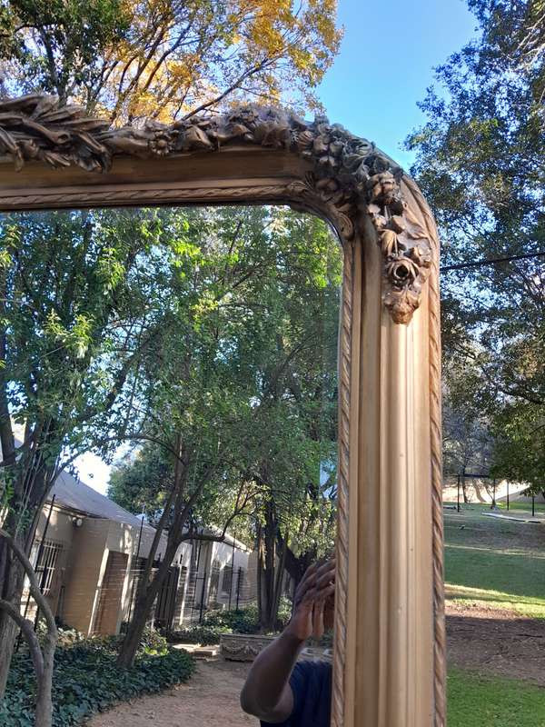 A Large French Style Ornately Carved and Gilded Bevelled Mirror
