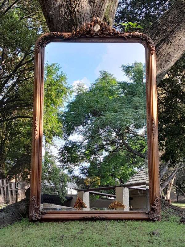A Large French Style Ornately Carved and Gilded Bevelled Mirror