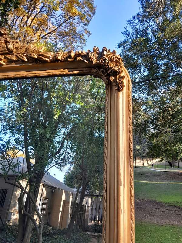 A Large French Style Ornately Carved and Gilded Bevelled Mirror