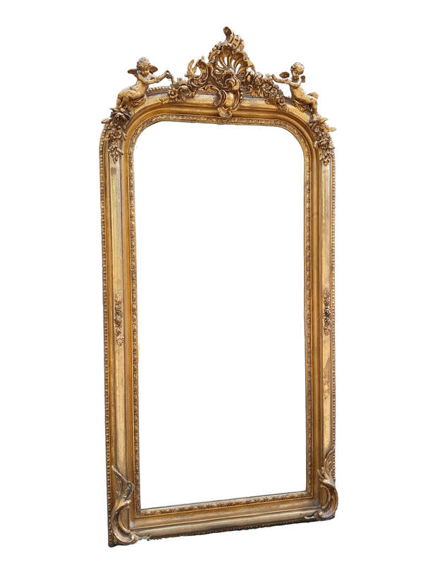 A French Style Ornately Carved And Gilded Bevelled Mirror
