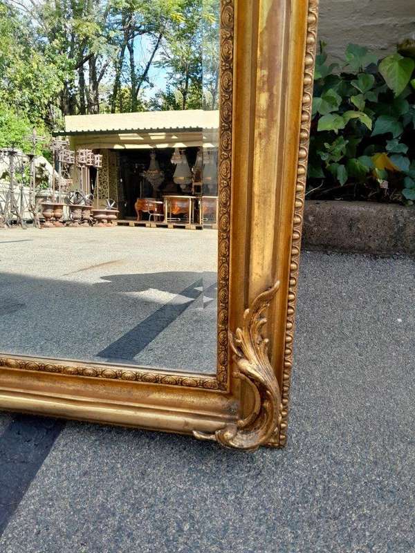A French Style Ornately Carved And Gilded Bevelled Mirror