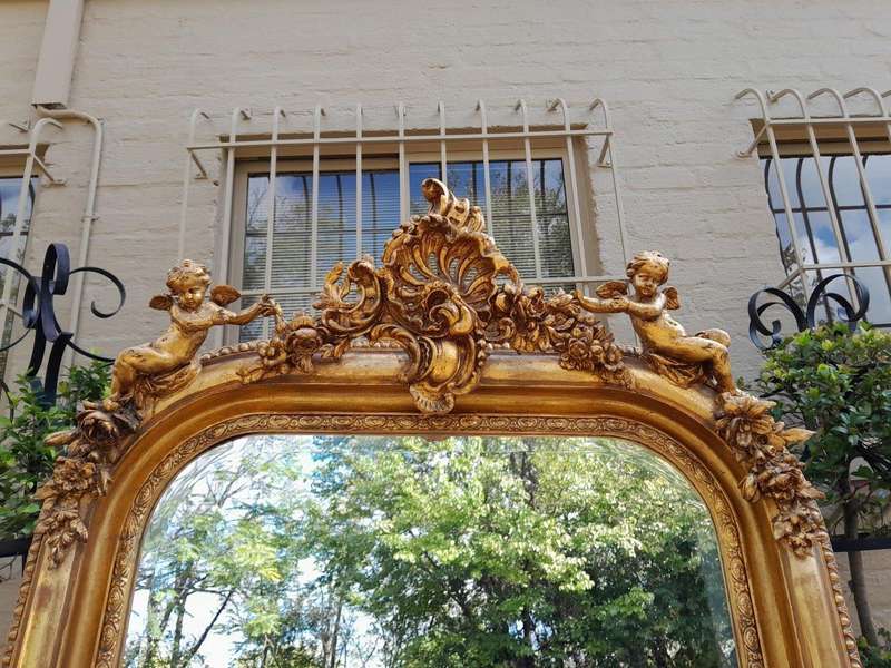 A French Style Ornately Carved And Gilded Bevelled Mirror