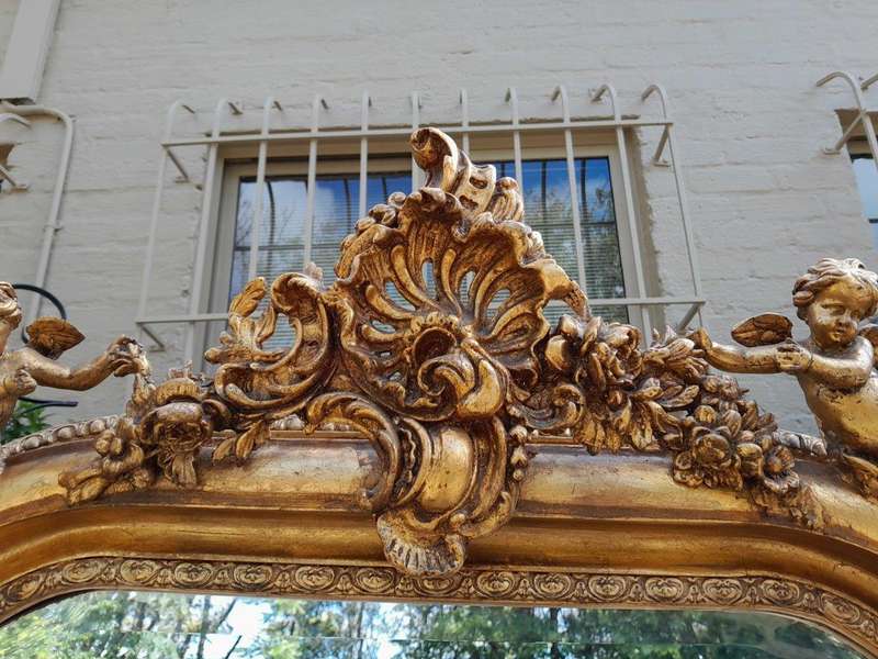 A French Style Ornately Carved And Gilded Bevelled Mirror