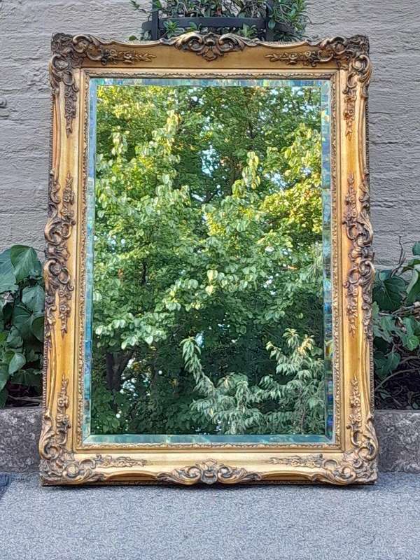 A 20th Century Heavily Carved, Gilded and Bevelled Mirror