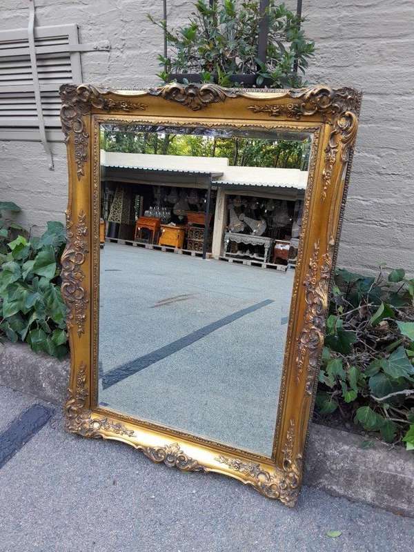 A 20th Century Heavily Carved, Gilded and Bevelled Mirror