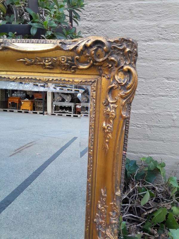 A 20th Century Heavily Carved, Gilded and Bevelled Mirror