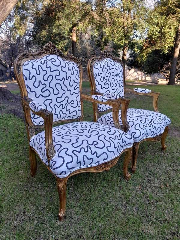 A 20th Century French Style Ornately Carved And Gilded Wooden Armchairs