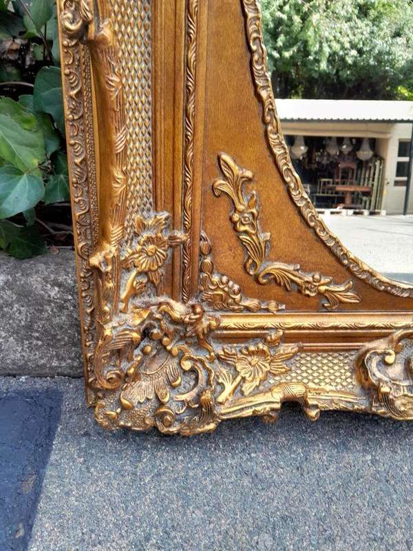 A 20th Century French Style Ornately Carved Bevelled and Gilt Wood Mirror