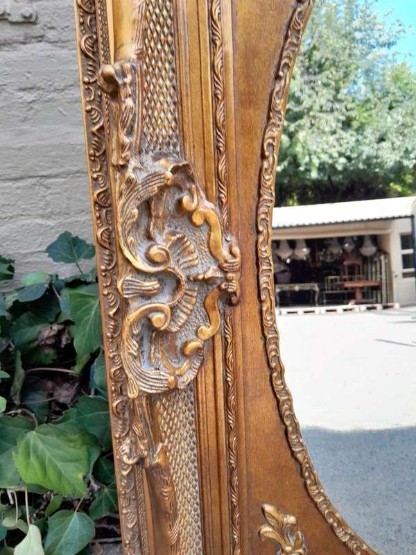 A 20th Century French Style Ornately Carved Bevelled and Gilt Wood Mirror