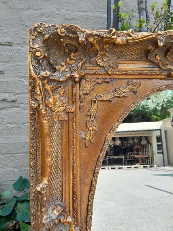 A 20th Century French Style Ornately Carved Bevelled and Gilt Wood Mirror