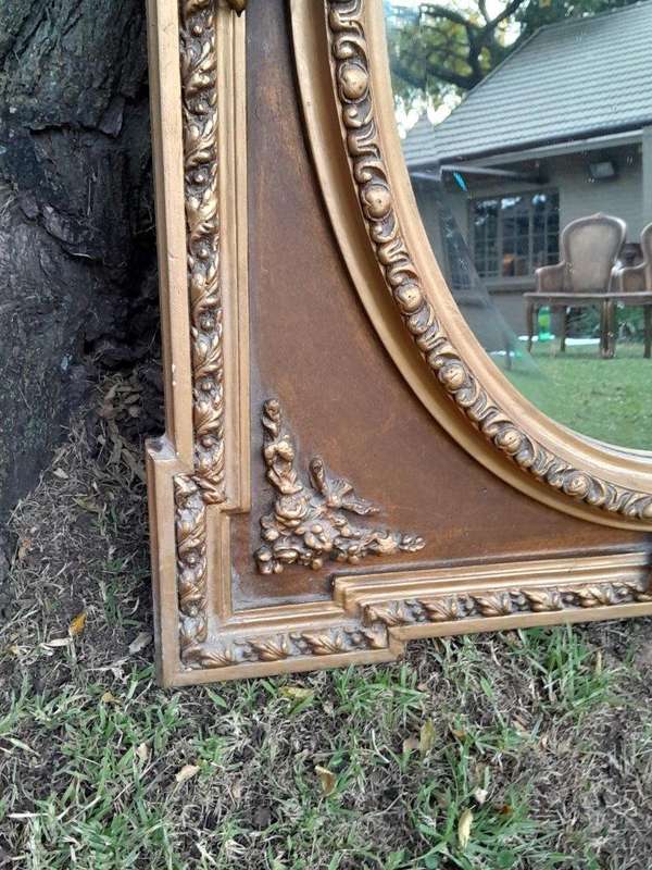 A French Rococo Style Ornately Carved and Gilded Bevelled Mirror
