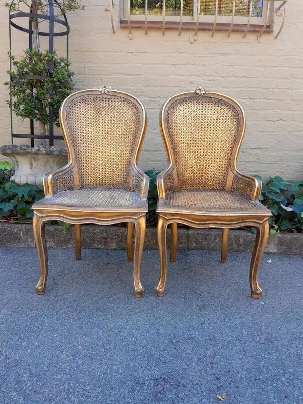 A Pair of French Style Ornately Carved and Gilded Rattan High Back Armchairs