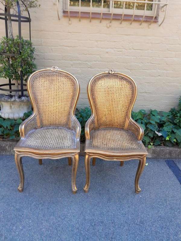 A Pair of French Style Ornately Carved and Gilded Rattan High Back Armchairs