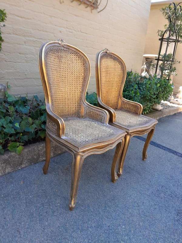 A Pair of French Style Ornately Carved and Gilded Rattan High Back Armchairs