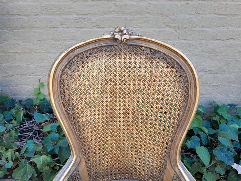 A Pair of French Style Ornately Carved and Gilded Rattan High Back Armchairs