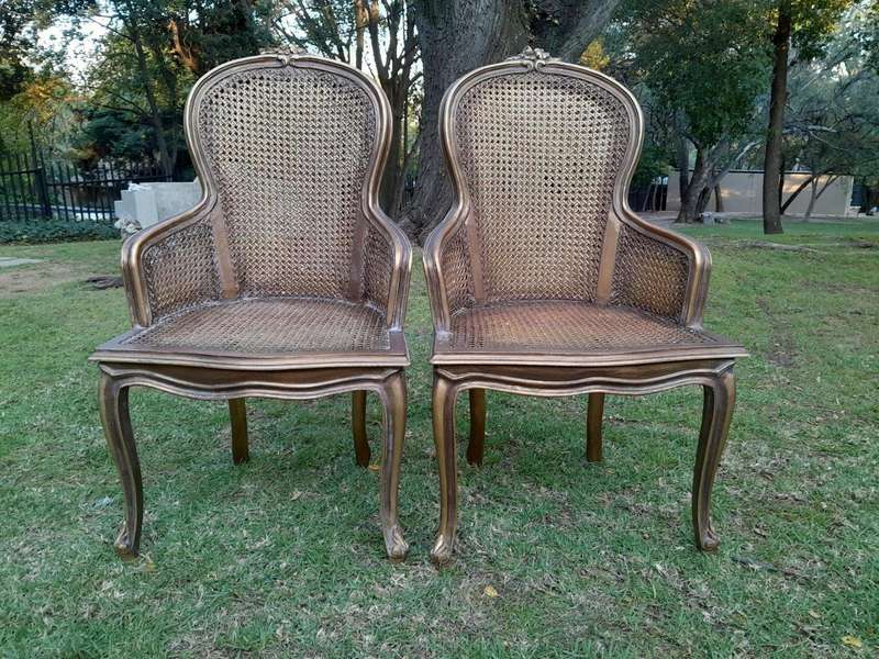 A Pair of French Style Ornately Carved and Gilded Rattan High Back Armchairs