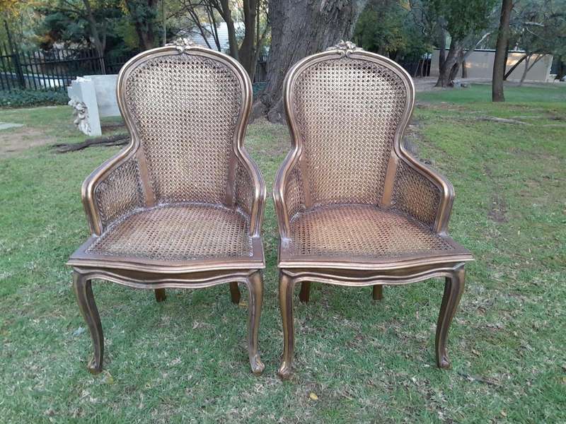 A Pair of French Style Ornately Carved and Gilded Rattan High Back Armchairs