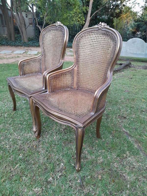 A Pair of French Style Ornately Carved and Gilded Rattan High Back Armchairs