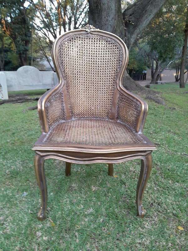 A Pair of French Style Ornately Carved and Gilded Rattan High Back Armchairs