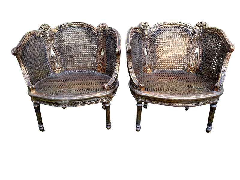 A French Louis XVI Style Pair of Ornately Carved Giltwood Rattan Bergere Chairs